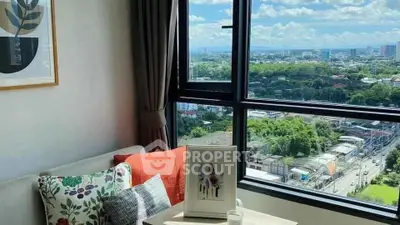 Charming living room with stunning city view from large window, cozy sofa, and stylish decor.