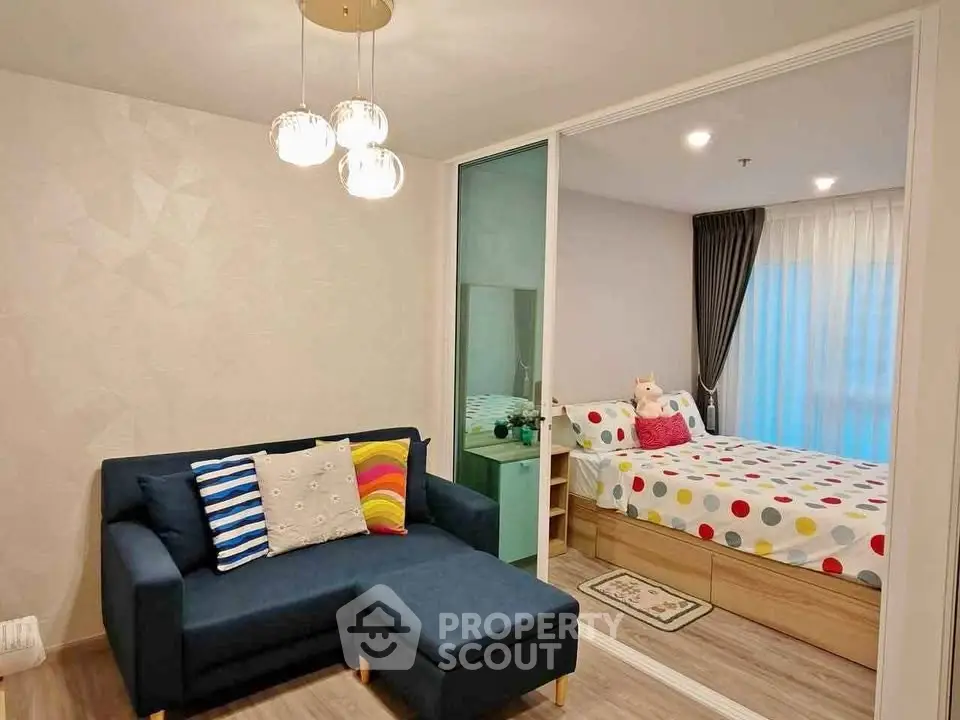 Modern apartment interior with cozy living room and stylish bedroom separated by glass wall.