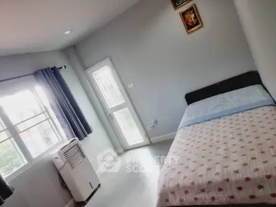 Cozy bedroom with natural light, featuring a comfortable bed and modern decor.