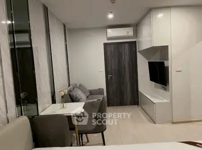 Modern living room with sleek furniture and wall-mounted TV in stylish apartment.