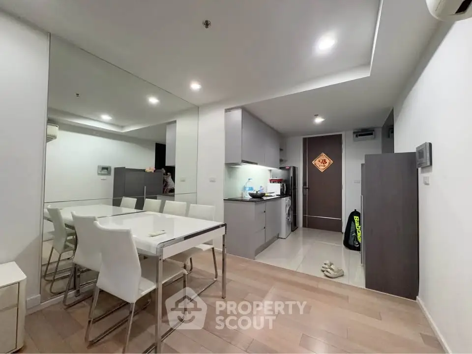 Modern open-layout kitchen and dining area with sleek design and ample lighting.