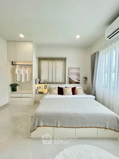 Modern bedroom with elegant decor, featuring a cozy bed, built-in wardrobe, and natural light from large windows.