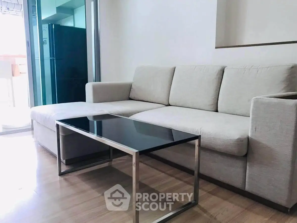 Modern living room with sleek sofa and glass coffee table, perfect for stylish urban living.
