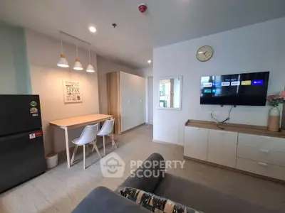 Modern living room with stylish decor and open layout, featuring a cozy dining area and sleek furniture.