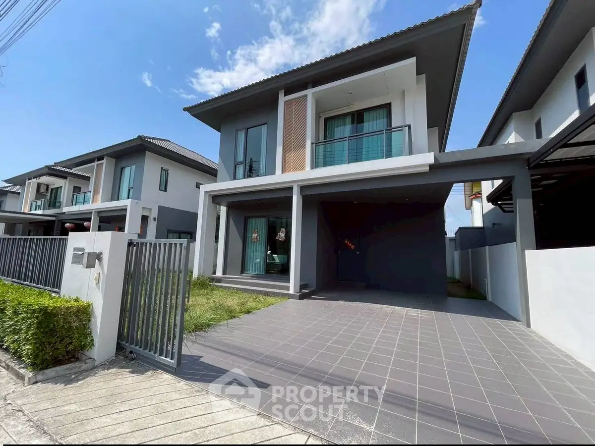 Modern two-story house with spacious driveway and sleek design in a suburban neighborhood.
