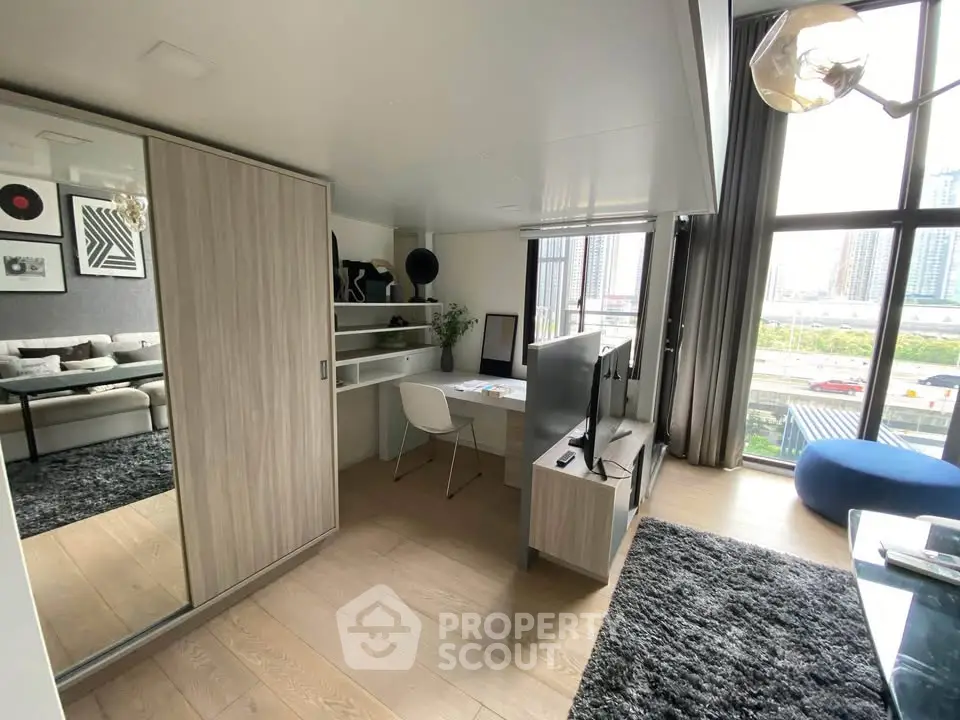 Modern studio apartment with stylish decor and city view, featuring a cozy living area and workspace.