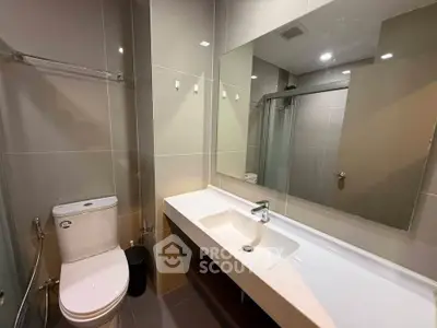 Modern bathroom with sleek fixtures and large mirror in a contemporary apartment.