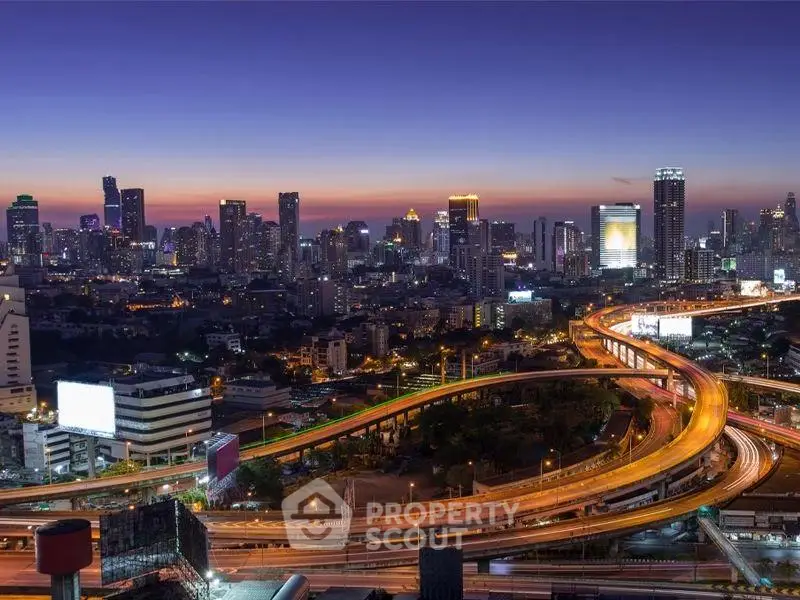 Stunning cityscape view showcasing vibrant skyline and illuminated highways at dusk.