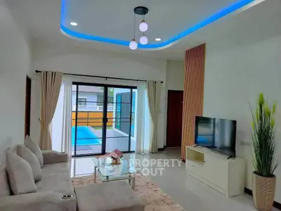 Modern living room with pool view, featuring sleek furniture and ambient lighting.
