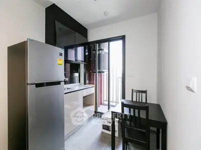 Modern compact kitchen with dining area and stainless steel fridge
