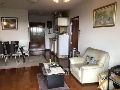 Cozy living room with dining area and compact kitchen in open layout apartment.
