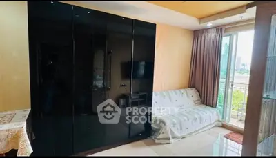 Modern living room with sleek black wardrobe and city view balcony.