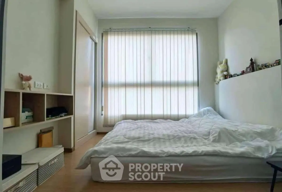 Cozy bedroom with large window and minimalist decor, perfect for relaxation and comfort.