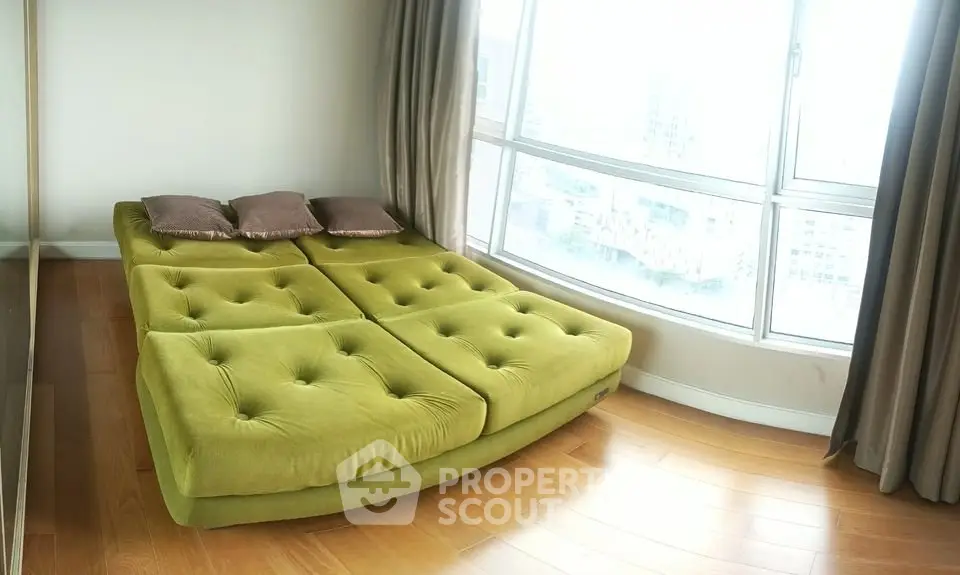 Spacious bedroom with large windows and modern green bed