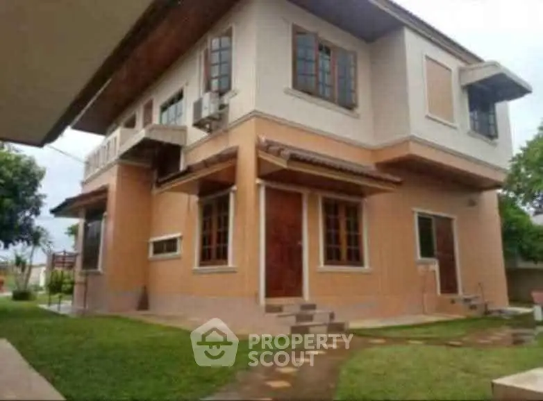 Charming two-story house with lush garden and modern exterior design.