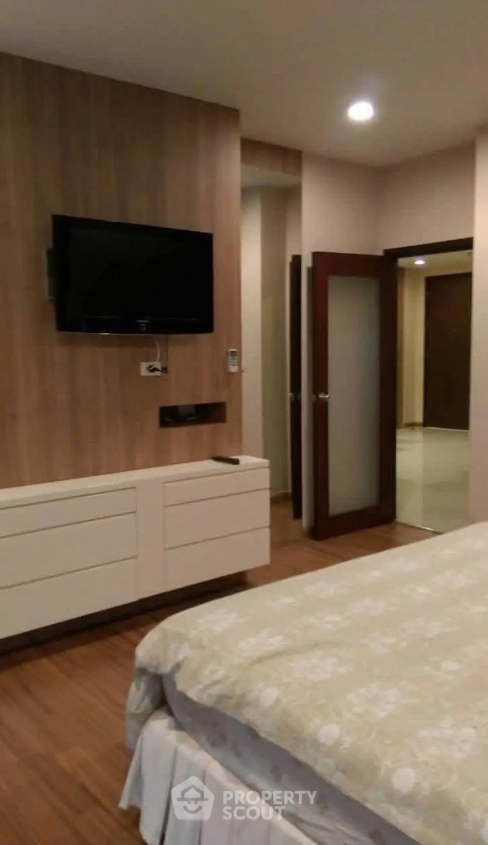 Modern bedroom with wall-mounted TV and elegant decor
