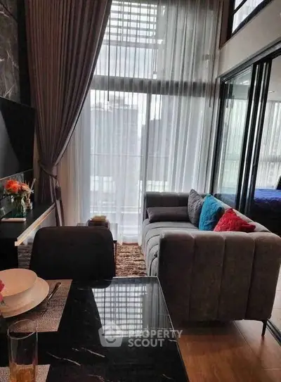 Modern living room with floor-to-ceiling windows and stylish decor in a luxury apartment.