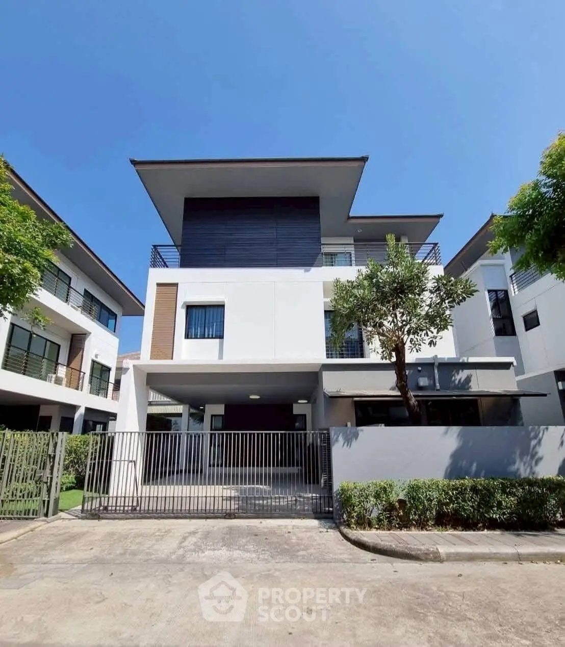 Modern three-story house with sleek design and spacious balcony in a serene neighborhood.