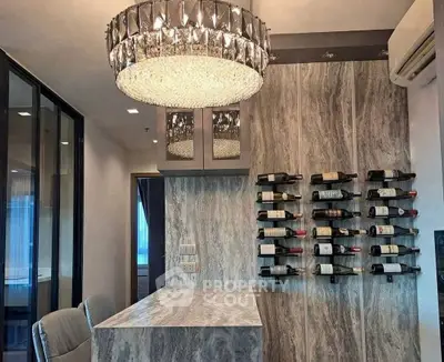 Luxurious modern kitchen with elegant wine rack and chandelier, perfect for entertaining.