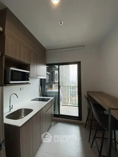 Modern kitchen with sleek cabinetry and balcony view in urban apartment