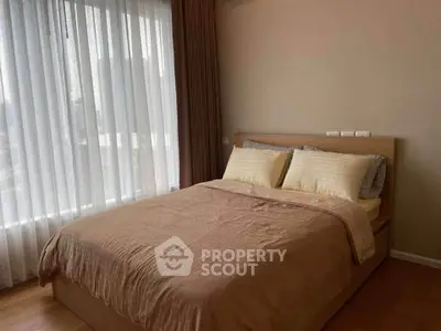 Cozy bedroom with large window and elegant curtains in modern apartment.