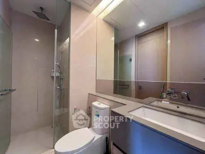 Modern bathroom with sleek fixtures and glass shower enclosure.
