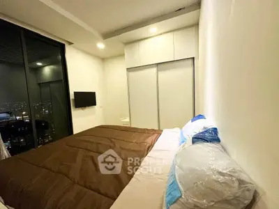 Modern bedroom with city view, featuring sleek design and ample storage space.