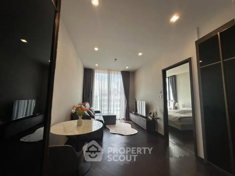 Modern living room with elegant decor and natural light, featuring a cozy seating area and stylish furnishings.