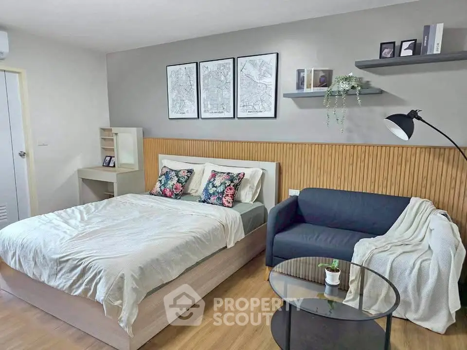 Modern bedroom with stylish decor, featuring a cozy bed, sleek sofa, and elegant wall art, perfect for urban living.