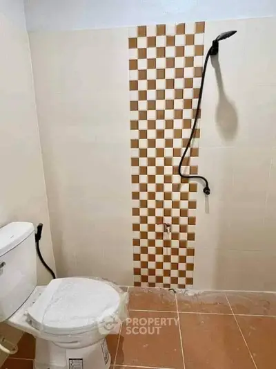 Minimalist bathroom with checkered tile accent and modern fixtures