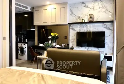 Modern living room with marble accent wall and integrated kitchen featuring washing machine and dining area.