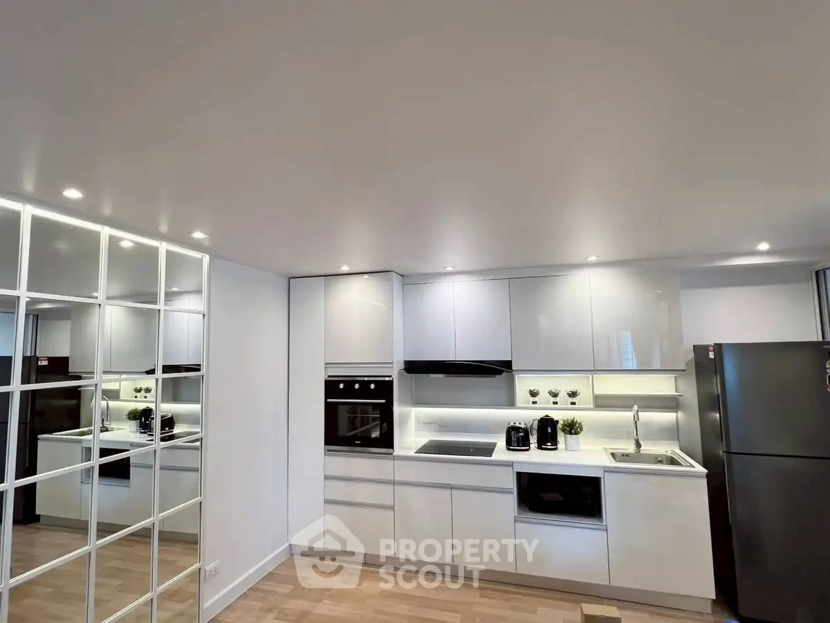 Modern kitchen with sleek white cabinets and built-in appliances