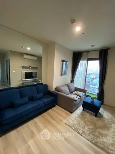 Modern living room with city view, featuring cozy sofas and stylish decor.