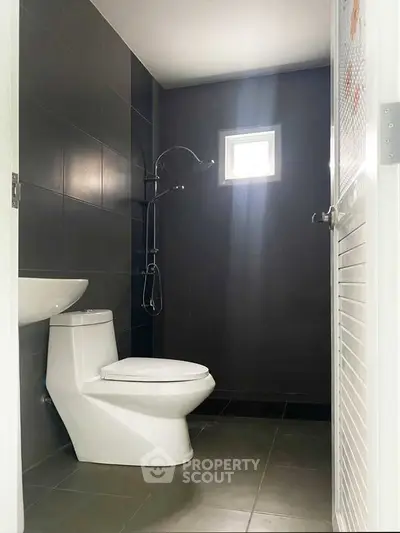 Modern bathroom with sleek black tiles and compact design