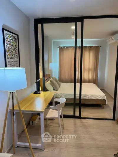 Modern studio apartment with glass partition, cozy bedroom, and stylish workspace.