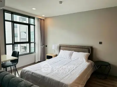 Modern bedroom with large window and stylish decor in urban apartment
