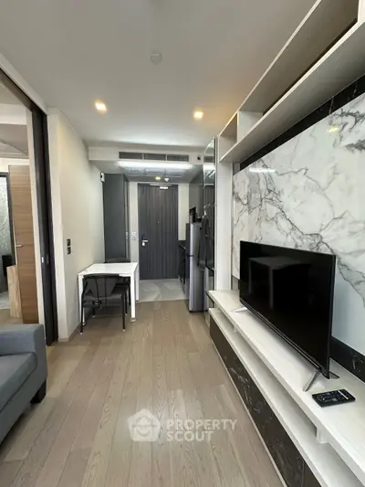 Modern living room with sleek design, featuring a TV, marble accents, and wooden flooring, perfect for urban living.