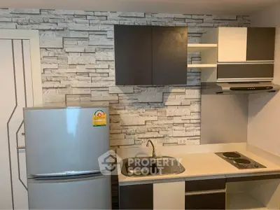 Modern compact kitchen with sleek cabinetry and stone accent wall