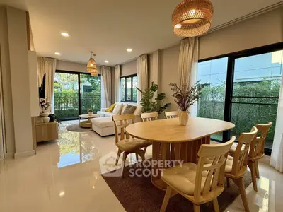 Spacious living and dining area with modern decor and large windows.