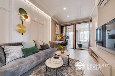 Elegant living room with plush grey sofa, modern decor, and abundant natural light streaming through large balcony doors.