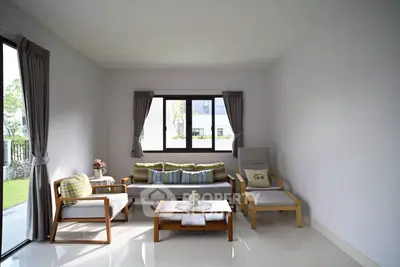 Modern living room with stylish furniture and large windows offering natural light.