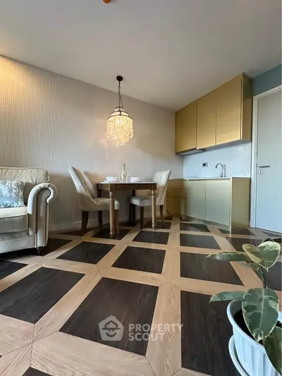 Elegant living room with modern kitchen, stylish chandelier, and unique flooring design