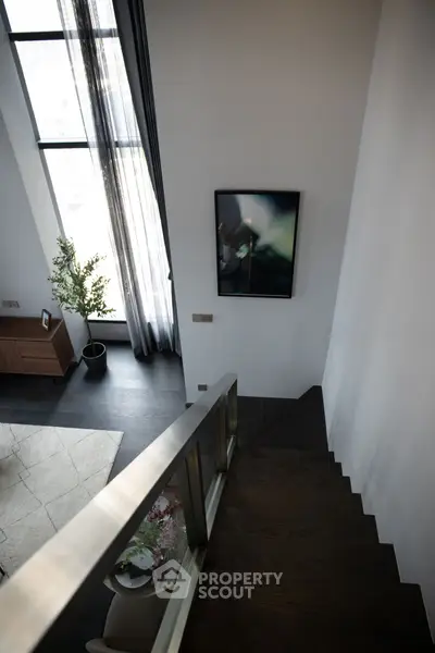 Modern duplex interior with sleek staircase and large window view