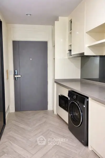 Modern kitchen with sleek appliances and stylish cabinetry in a contemporary apartment.