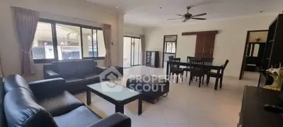 Spacious living room with modern furniture and dining area, featuring large windows and ceiling fan.