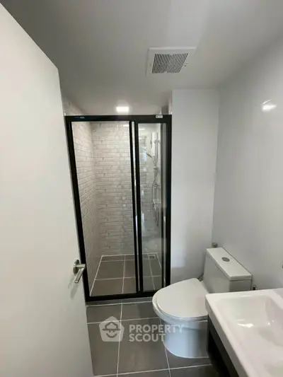 Modern bathroom with sleek design featuring glass shower and contemporary fixtures.