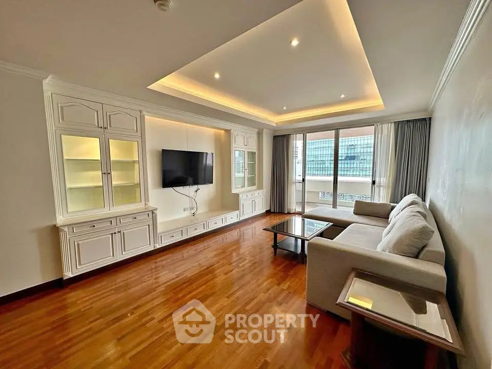 Spacious living room with elegant wood flooring and modern furnishings in a high-rise apartment.