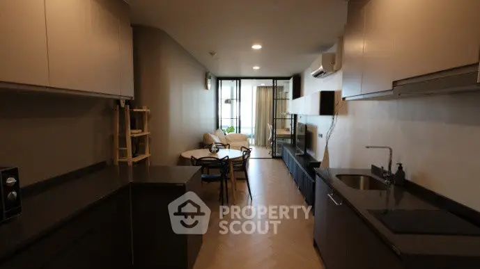 Modern open-layout kitchen and living room with sleek design and cozy seating area.