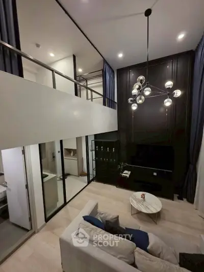 Luxurious modern living room with high ceilings and elegant chandelier in a stylish duplex apartment.