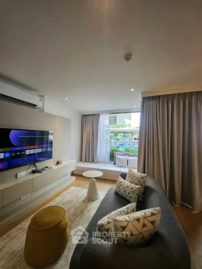 Modern living room with stylish decor and large window offering garden view.